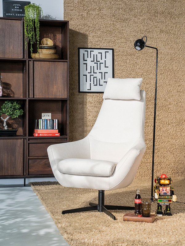 Off-white draaifauteuil met armleuning op zwart metalen draaipoot in retro setting.