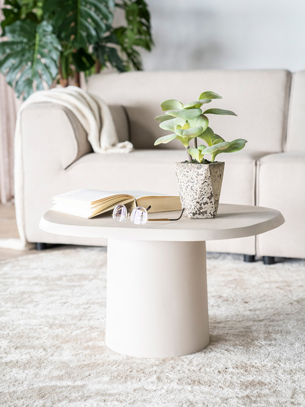 beige salontafel met organische blad en ronde kolompoot op beige vloerkleed voor beige bank. Woonstijl New Basic.